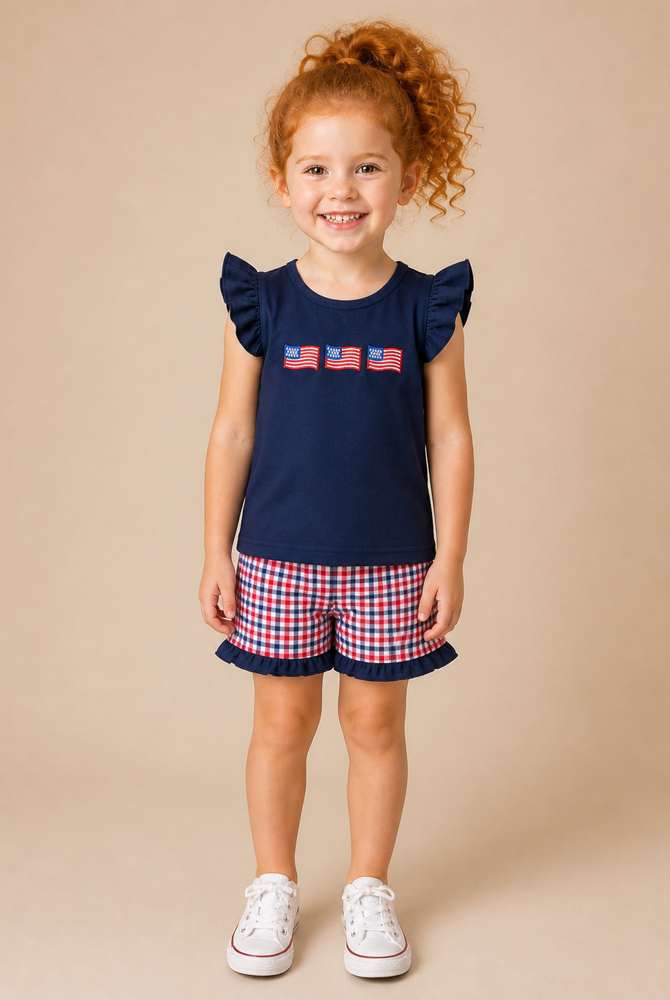 Red hair girl with navy shirt with flags on the front and plaid shorts.