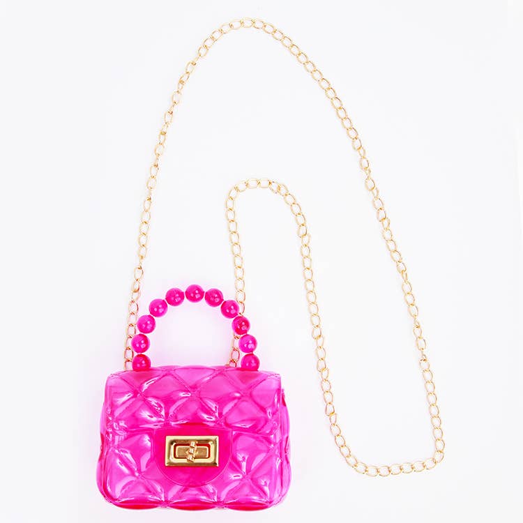 Pink quilted handbag with beaded handle on a white background