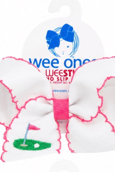 White hair bow with pink trim and golf design, branded 'wee ones'.