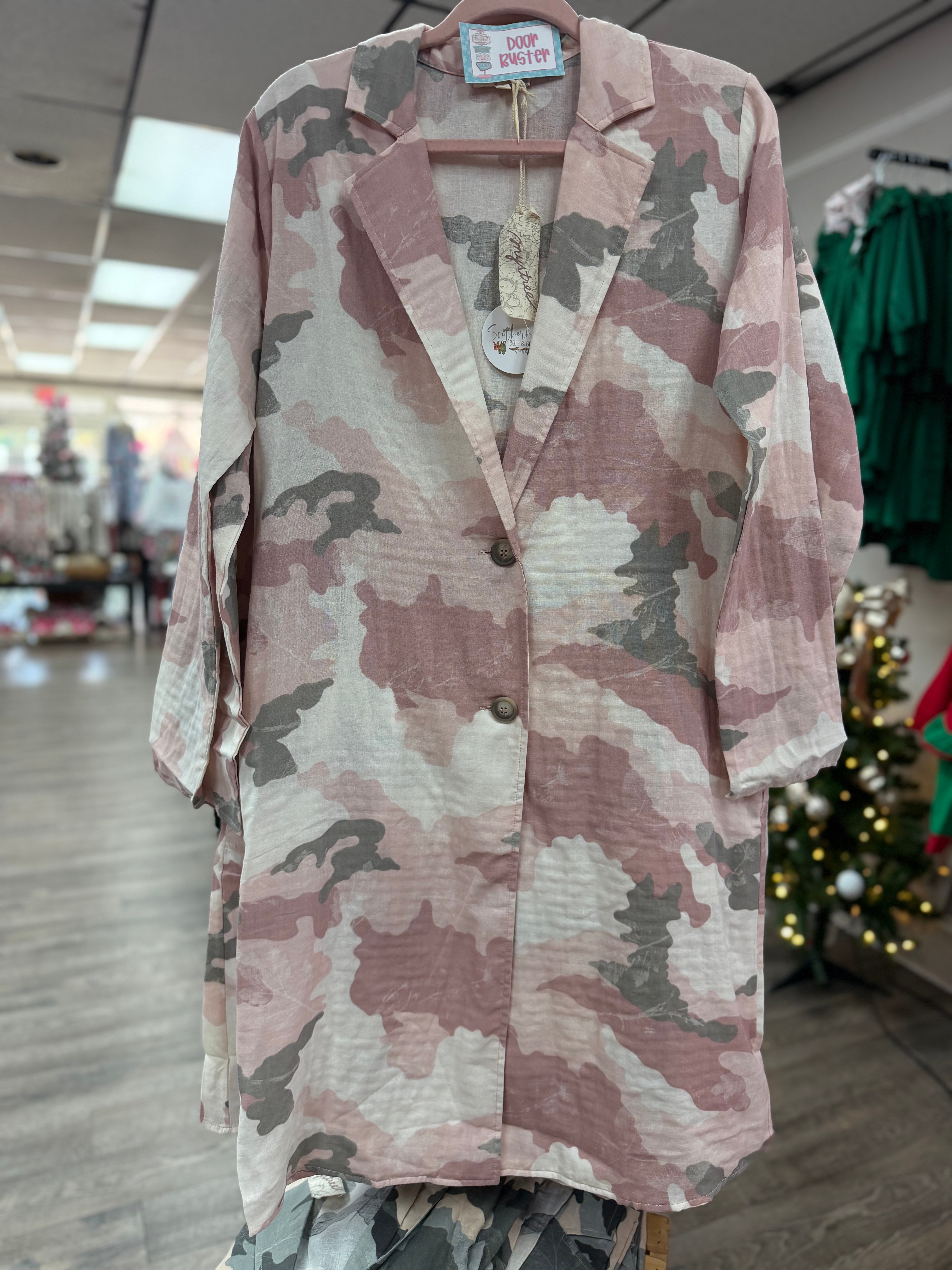 Camouflage-patterned jacket on a hanger in a store setting