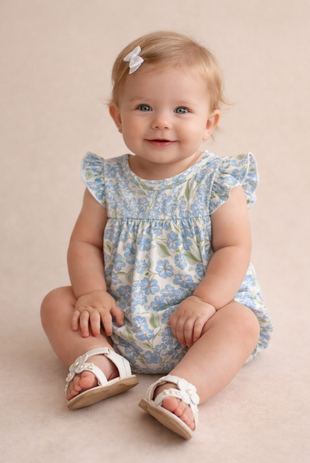 Baby wearing a floral dress and sandals on a beige background