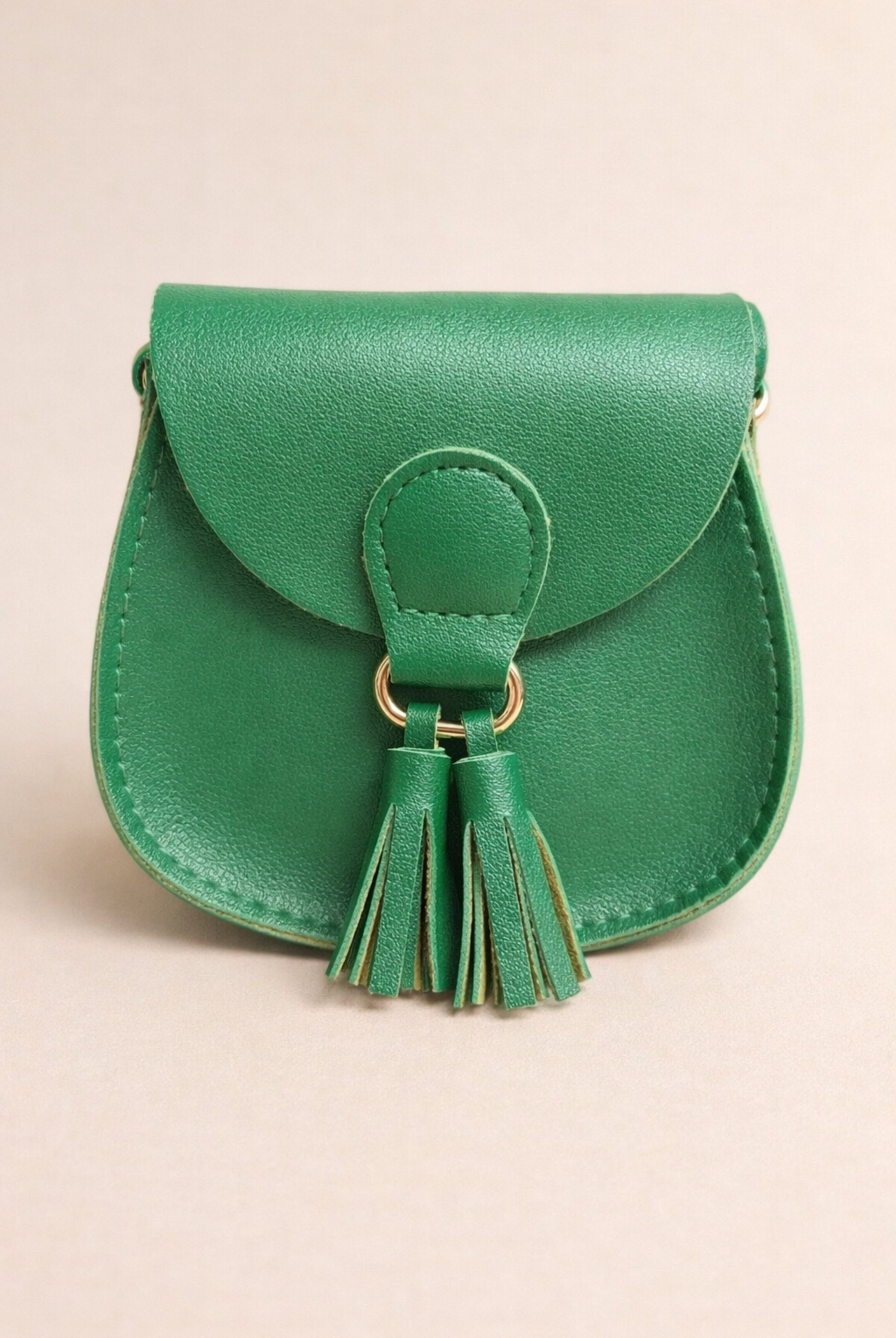 Green leather purse with a tassel on a beige background