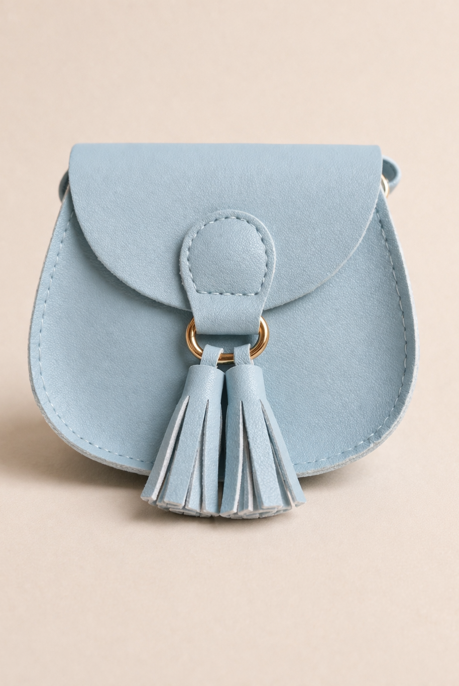 Light blue handbag with a tassel on a beige background