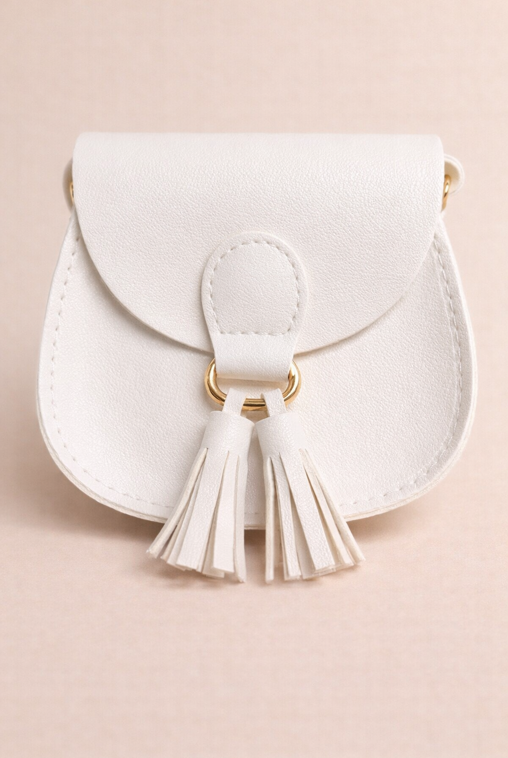 White handbag with tassel detail on a beige background