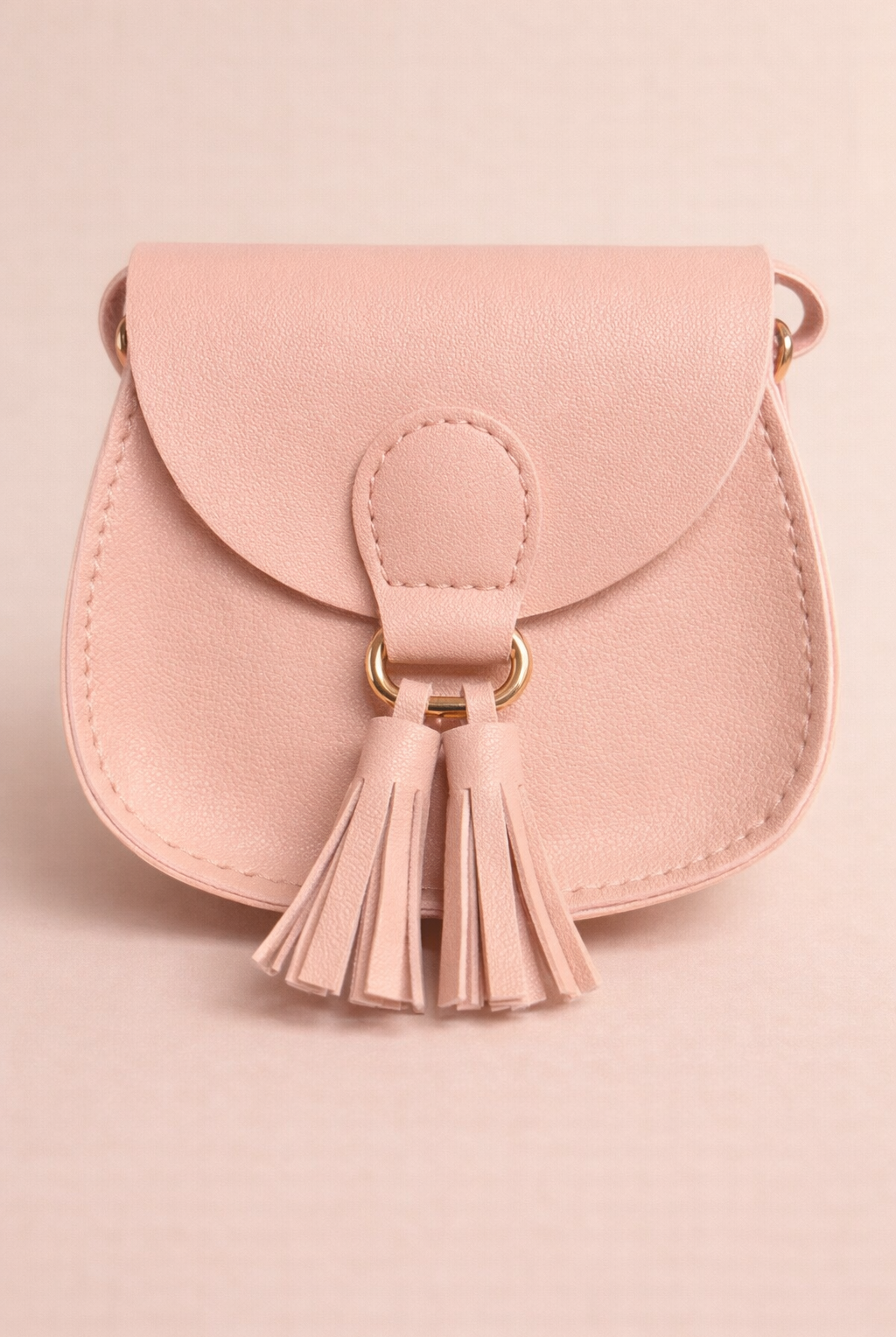 Pink handbag with a tassel on a pink background