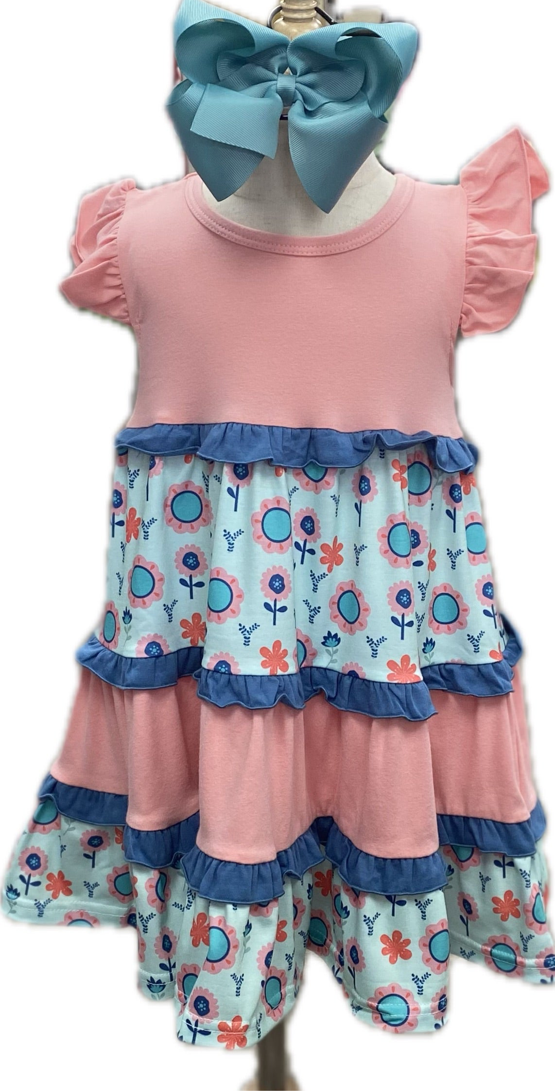 Children's outfit with pink top and floral shorts on a mannequin.
