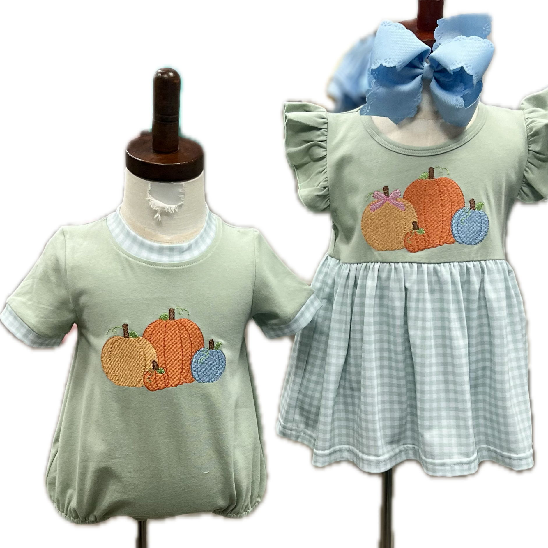 Two children's outfits on mannequins with pumpkin design on a light green background