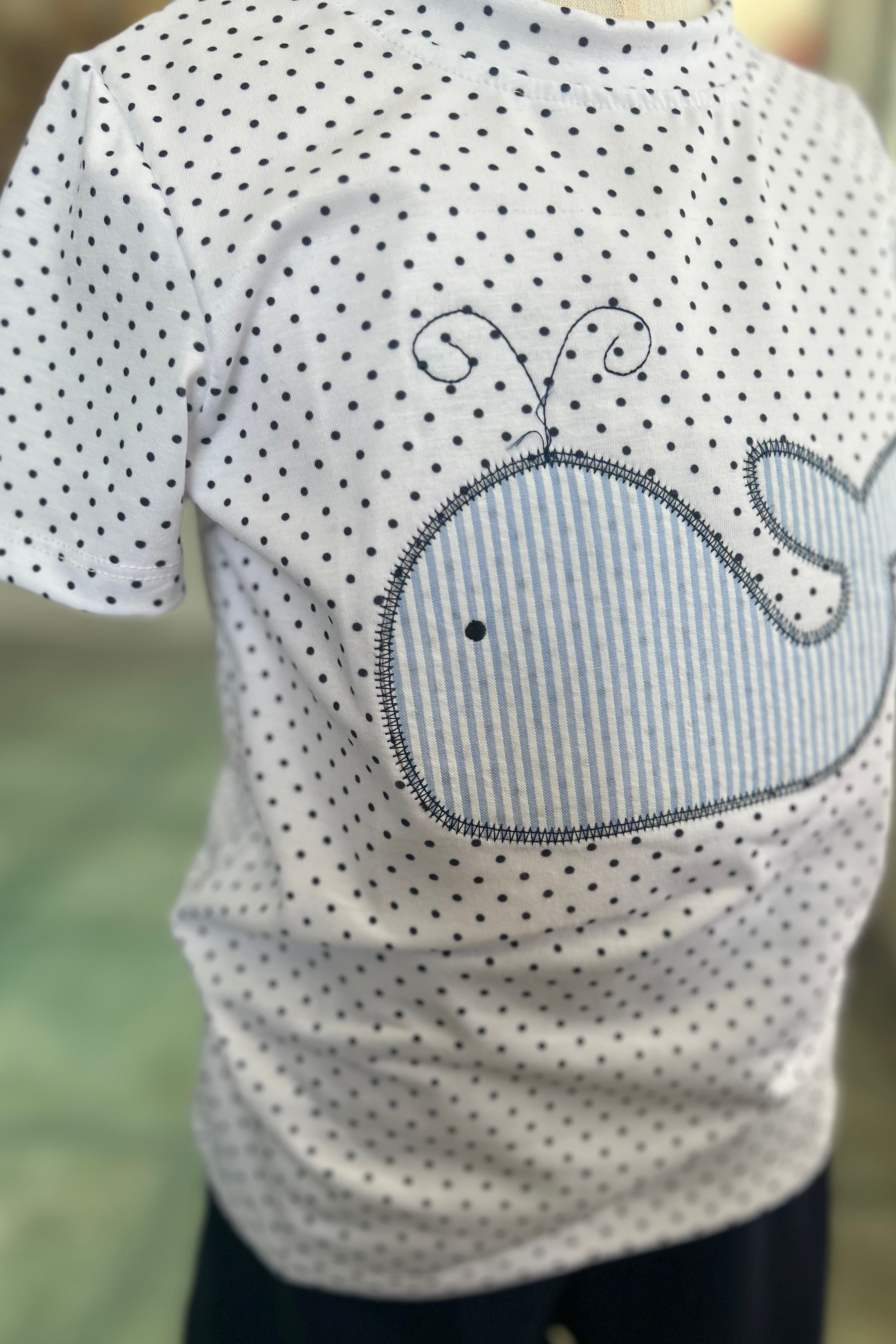 Children's t-shirt with whale design on a blurred background