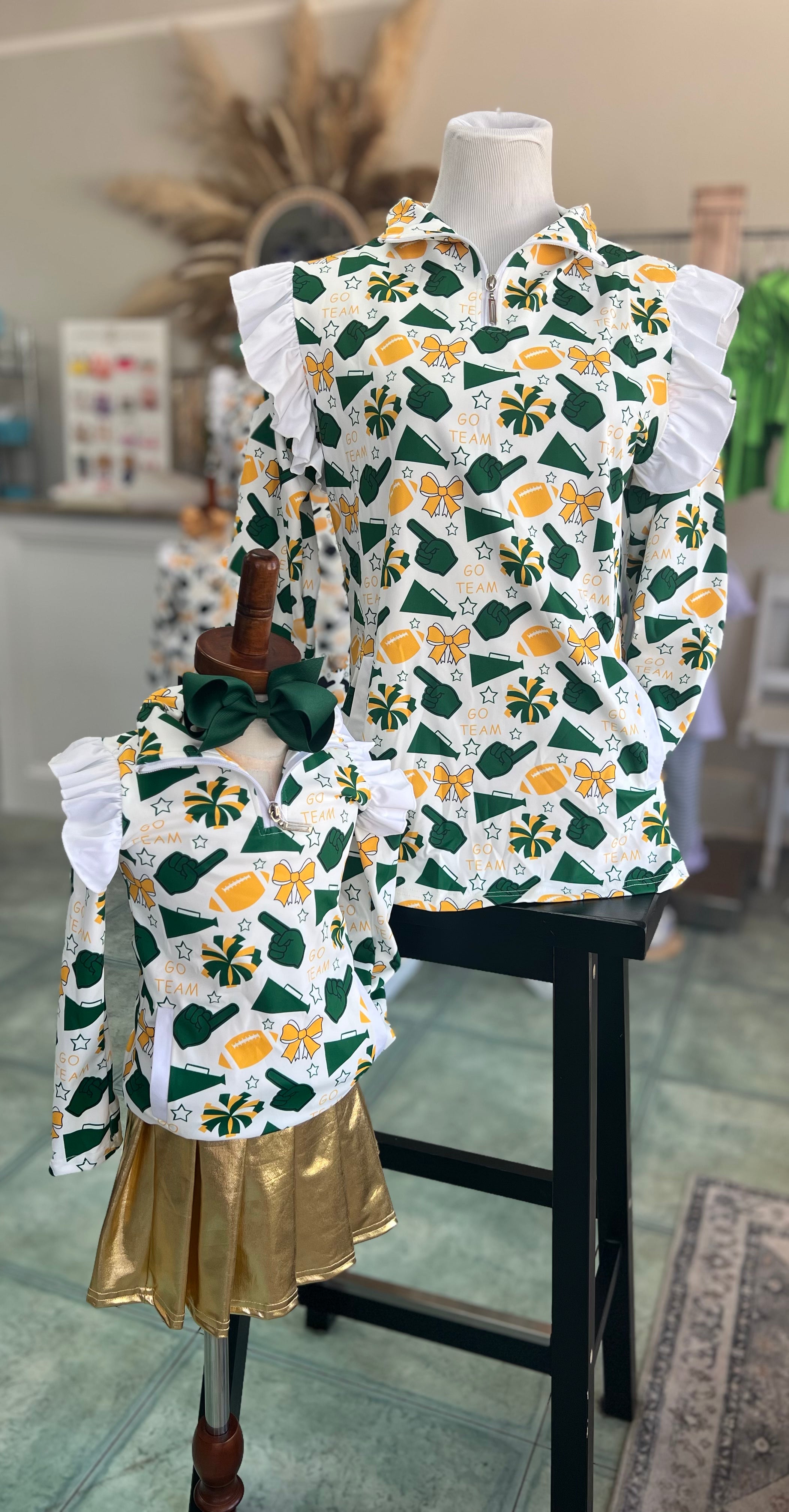 Children's outfit with football and cheer patterned top and gold skirt on a mannequin.