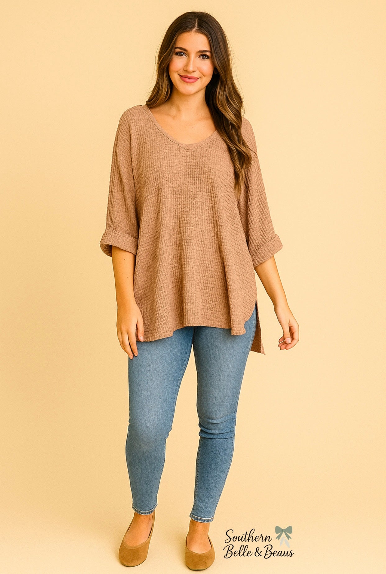 Woman wearing a beige sweater and blue jeans on a beige background with 'Southern Belle & Beau's' branding.