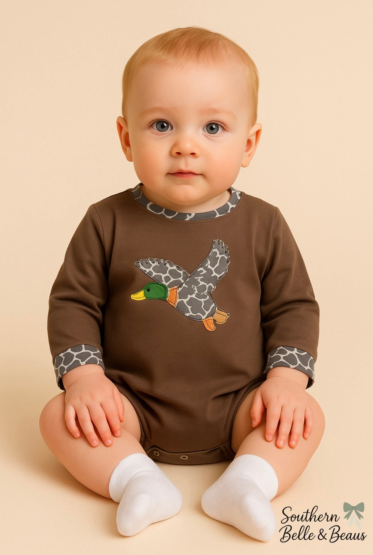 Baby wearing a brown bubble with a duck design.