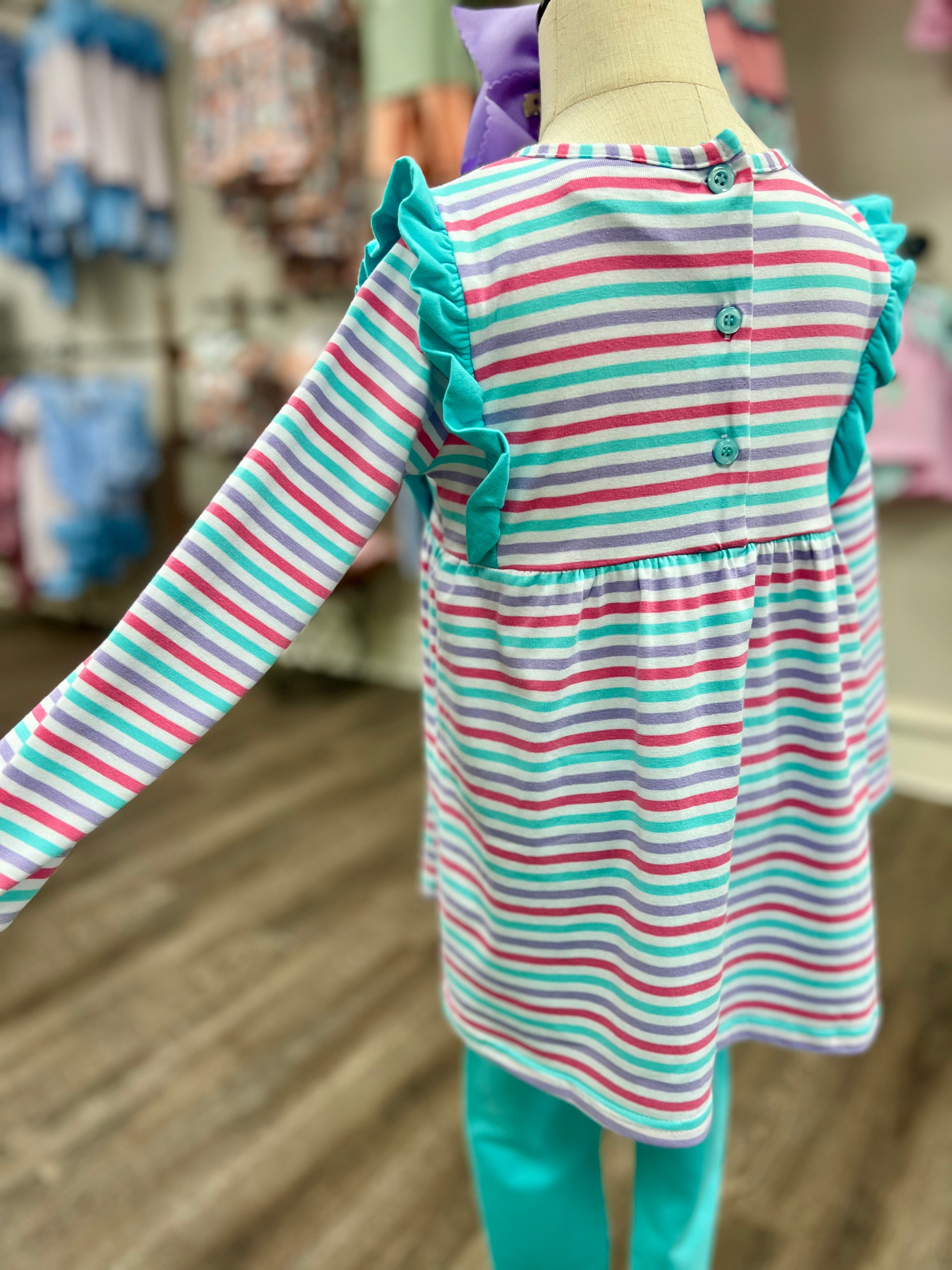 Striped dress with ruffled details on a mannequin in a store setting