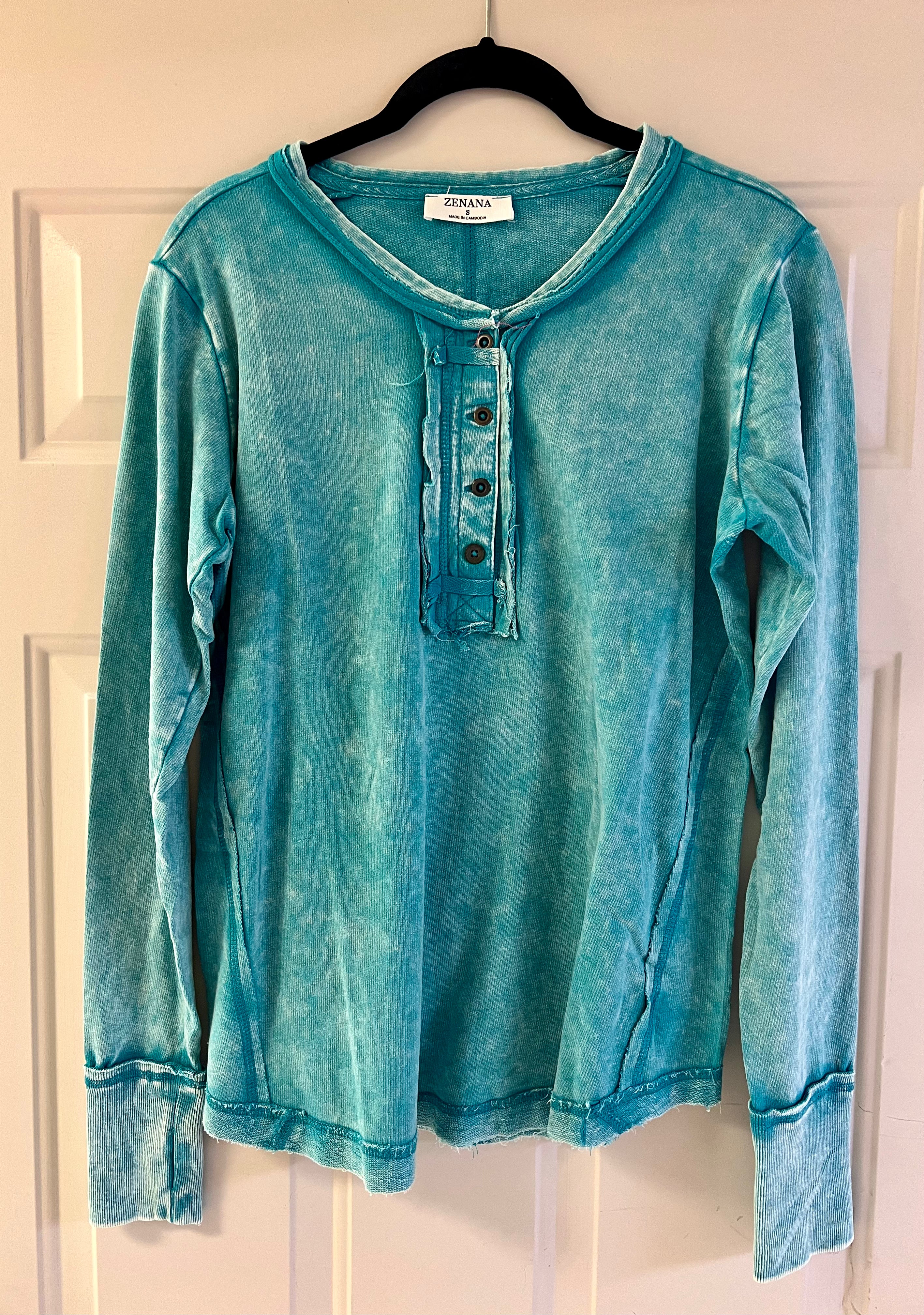 Teal long sleeve ladies shirt with cuffed sleeves.