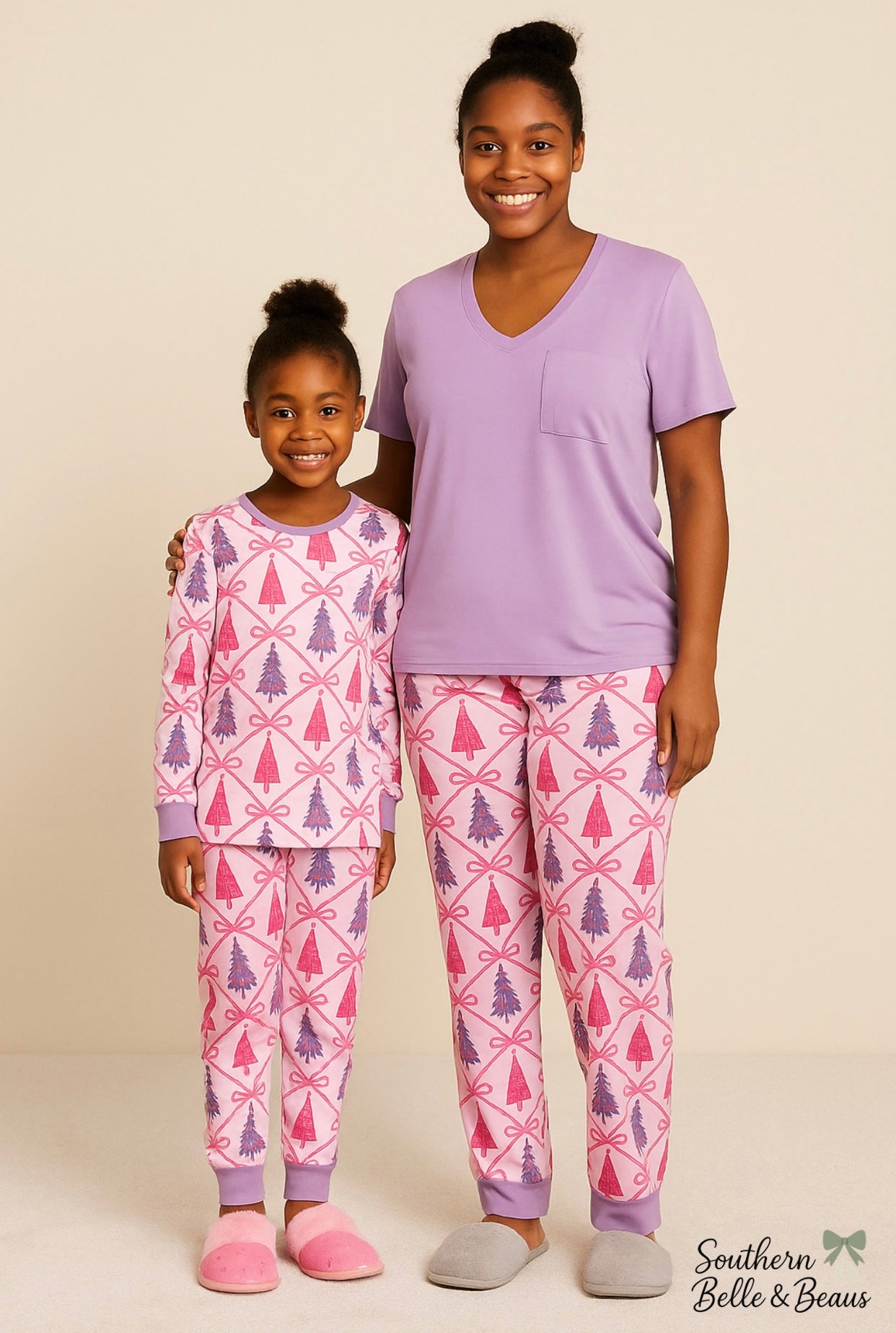 Two people wearing matching pink and purple pajama sets with geometric patterns on a beige background.