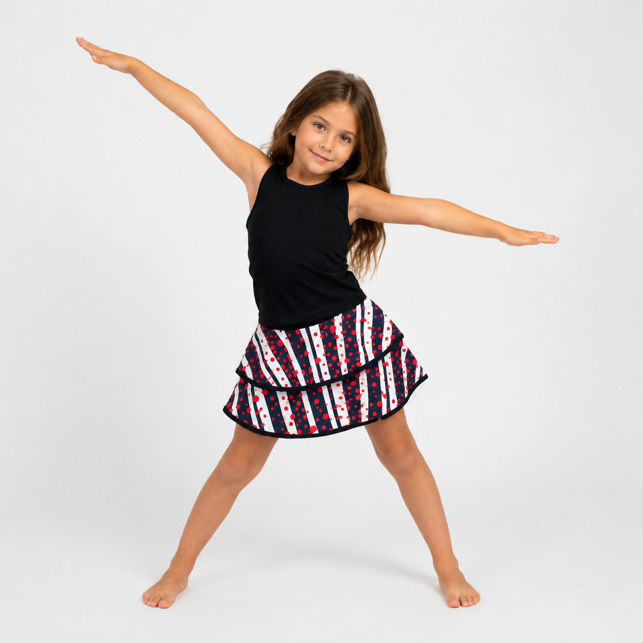 Young girl in a black top and red, white, and blue striped skirt on a white background