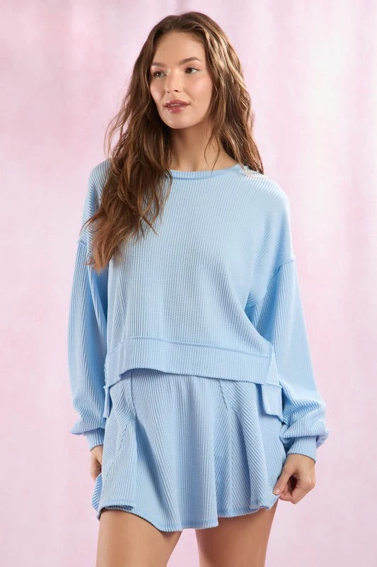 Woman wearing a light blue outfit against a pink background