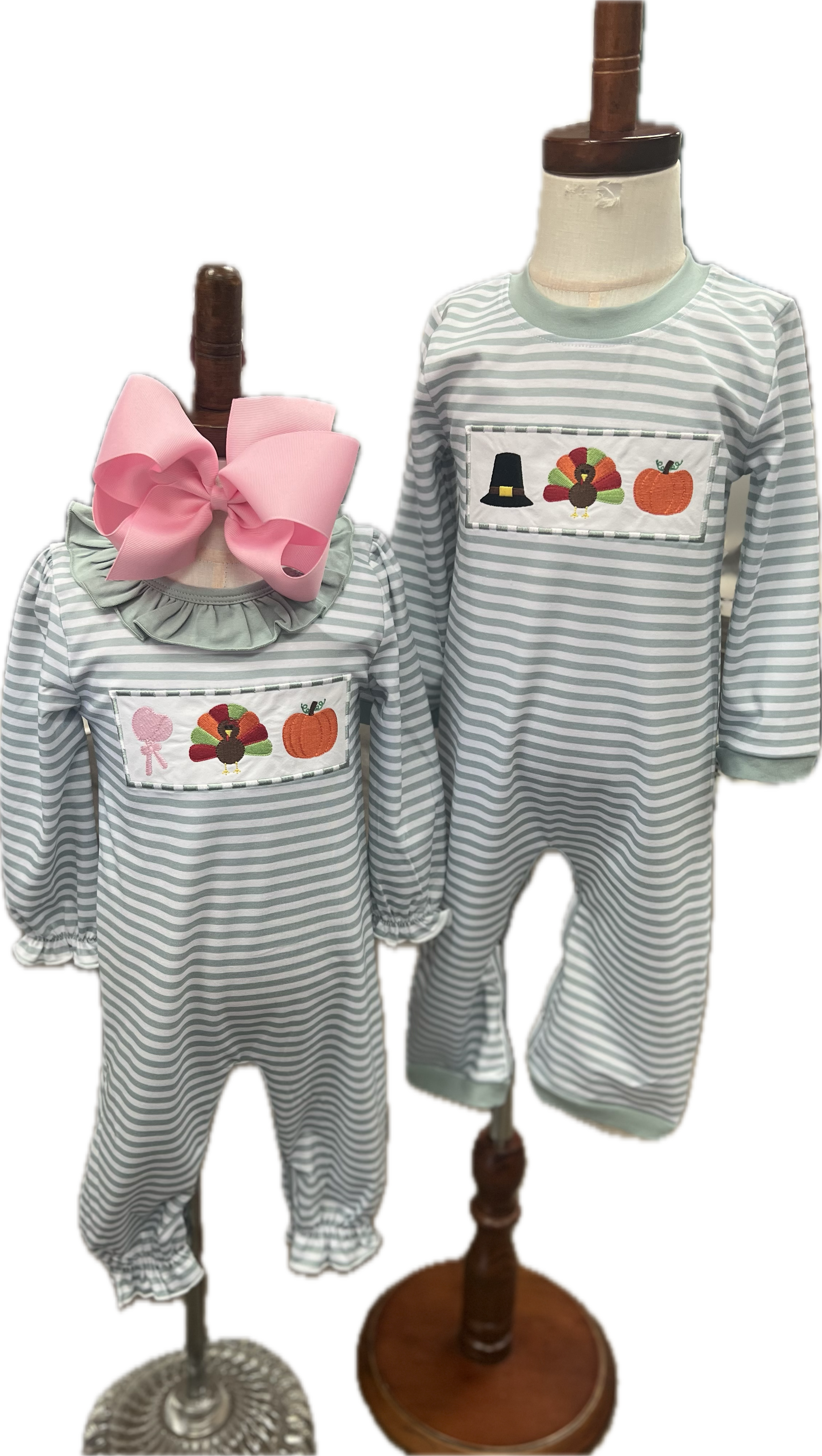 Two children's outfits on mannequins with striped pattern and embroidered designs.