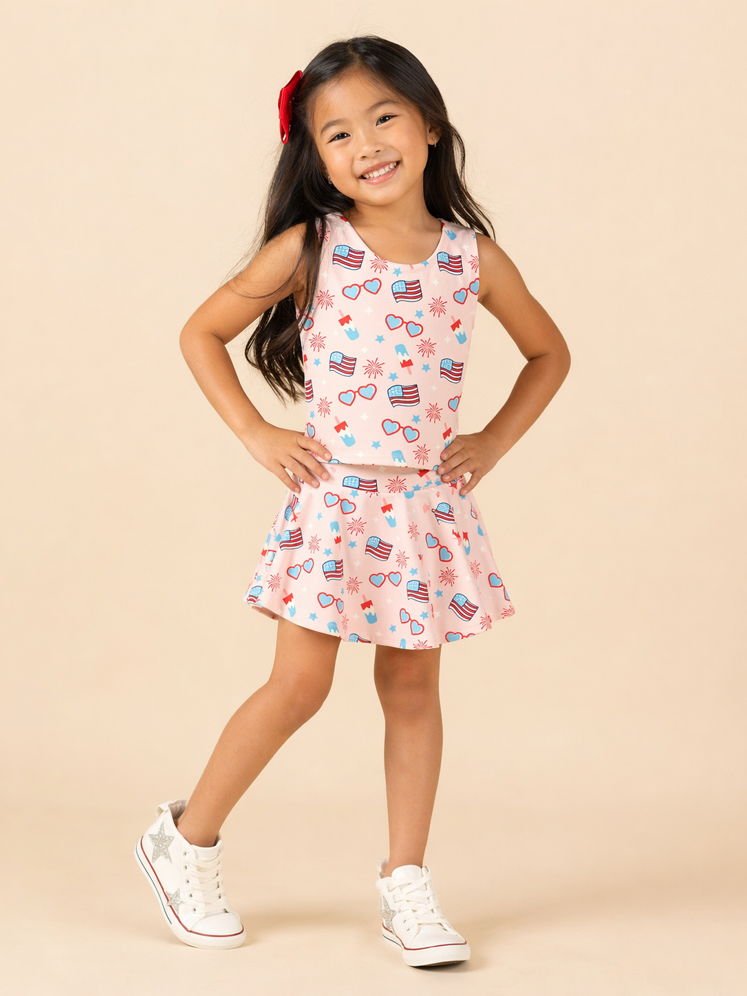 Young girl wearing a sleeveless top and skirt with American flag pattern on a beige background
