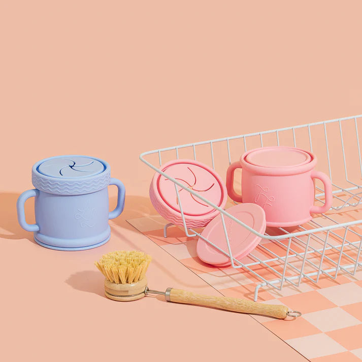 Colorful silicone cups and a scrubber on a pink background