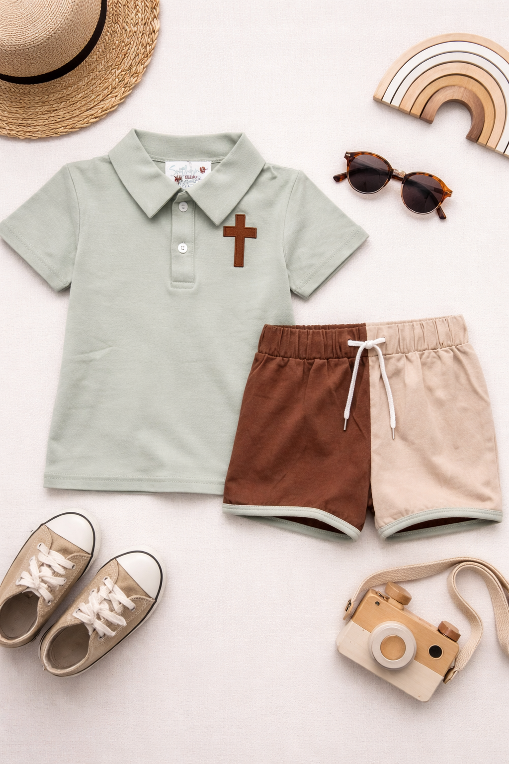Sage green polo with an embroidered cross and drawstring brown & khaki shorts.