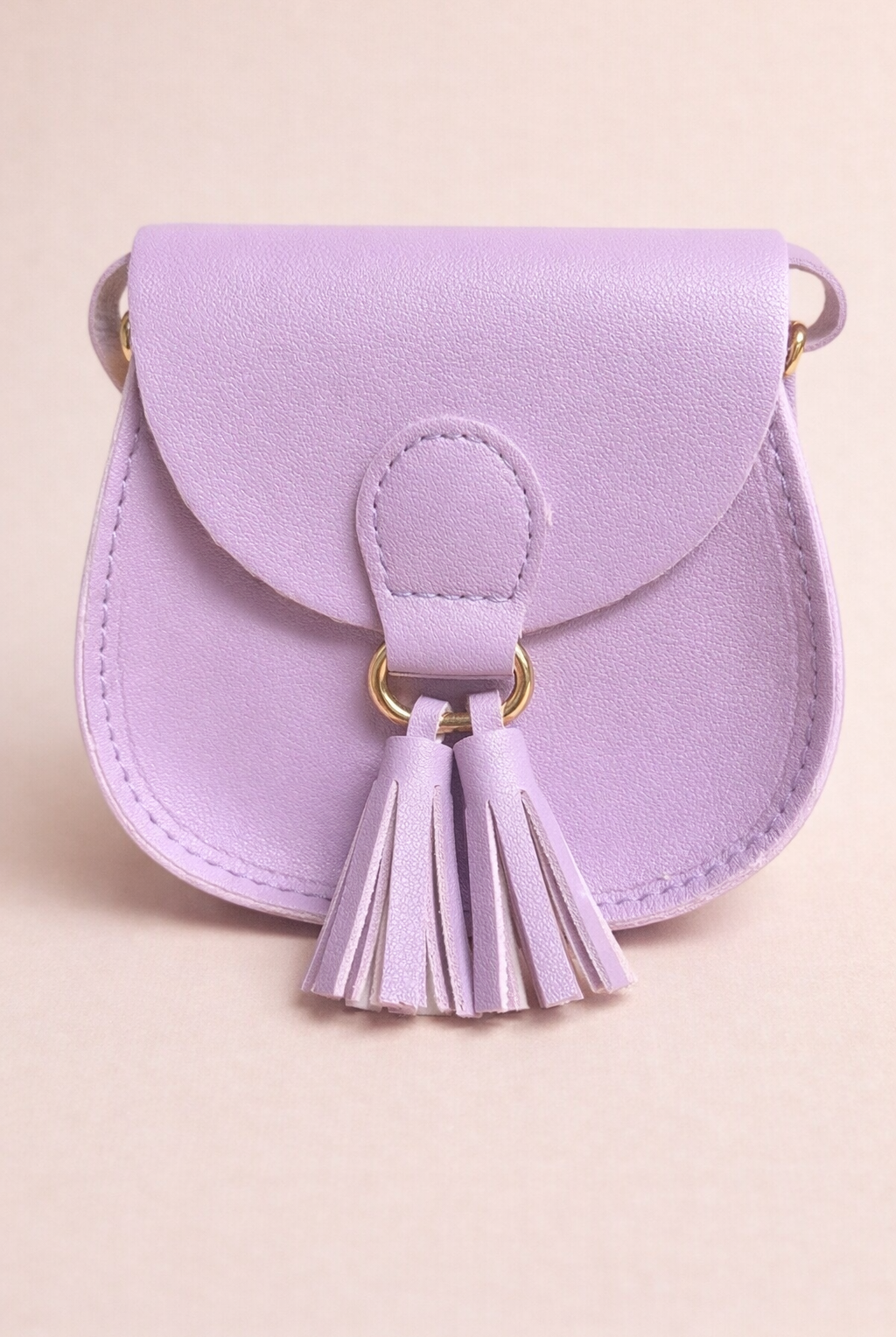 Lavender handbag with tassels on a beige background
