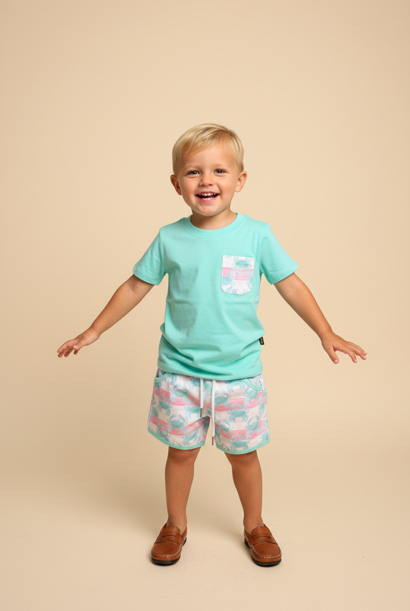 Toddler boy wearing aqua mint shirt with crab print pocket and matching shorts.