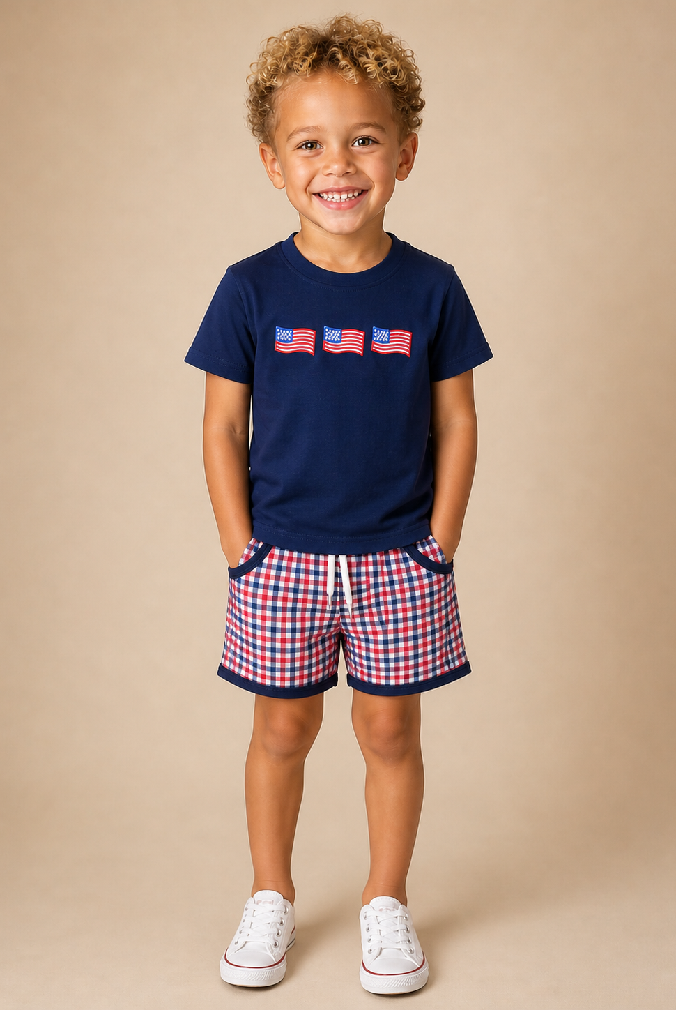 Boy wearing a navy shirt with flags on the front and plaid shorts
