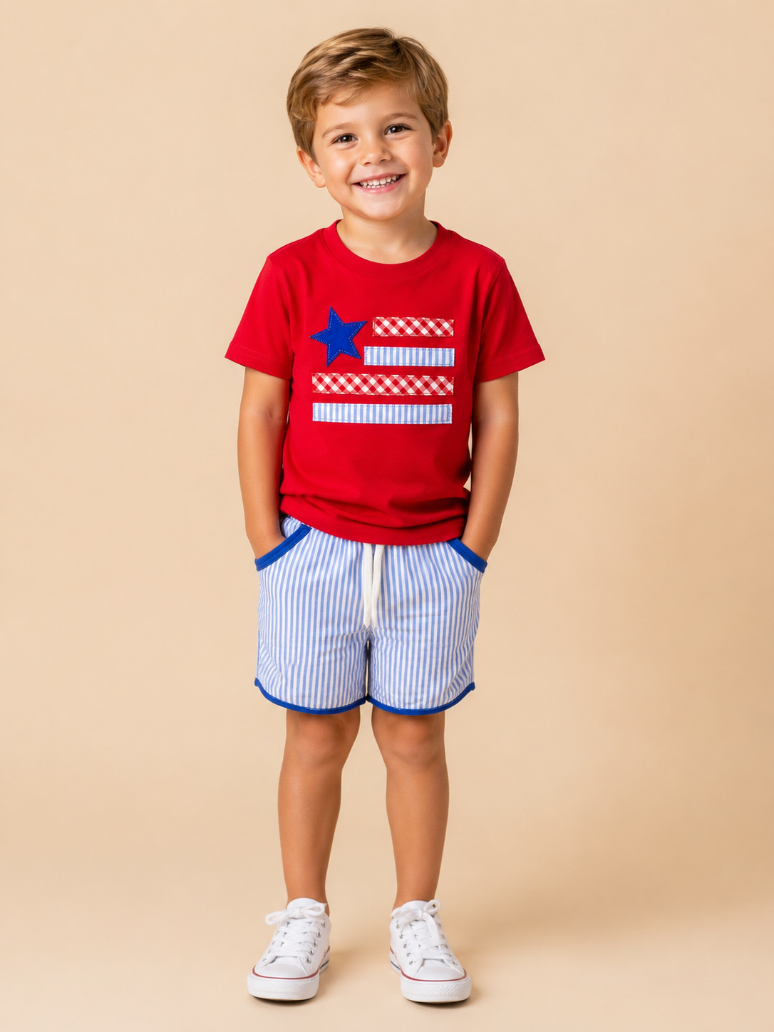 Child wearing a red t-shirt with a blue star and white stripes, paired with blue shorts on a beige background
