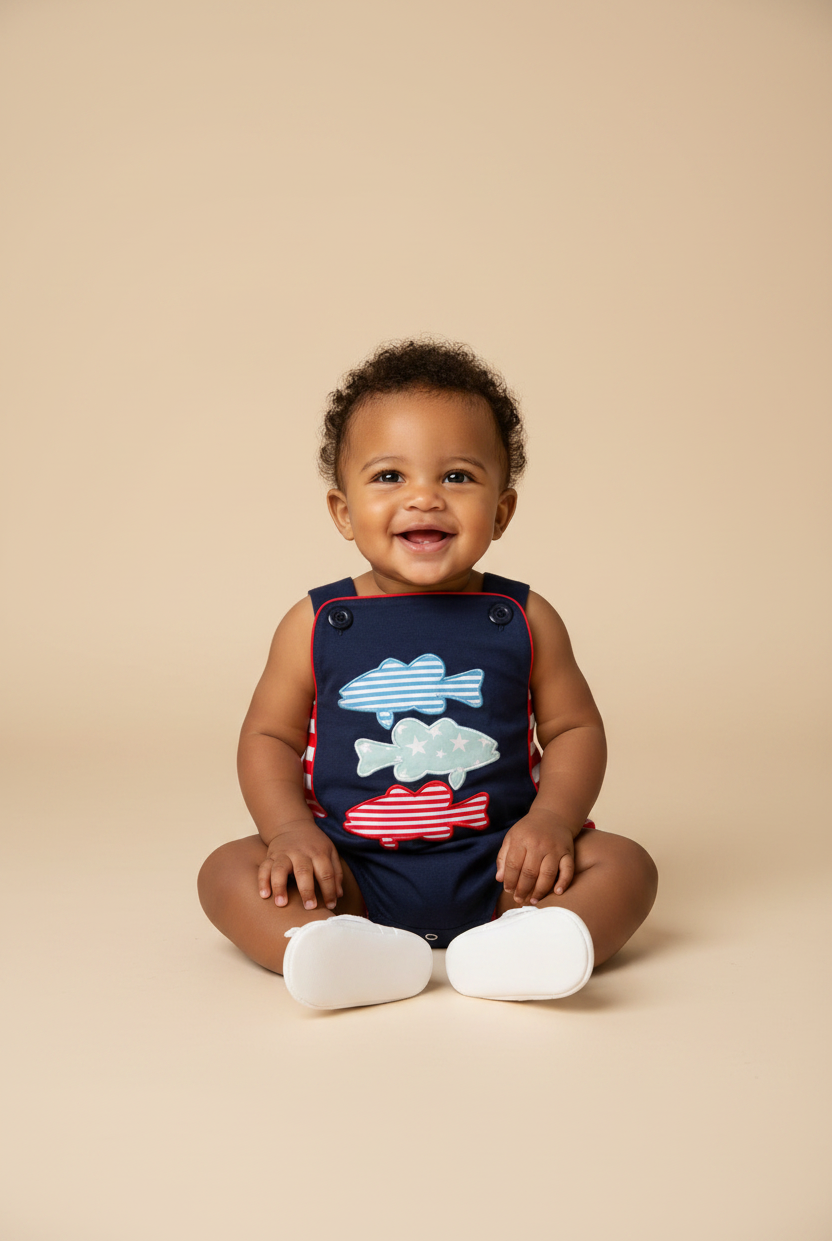 Baby boy model wearing a navy bubble with three fish stacked emboridery.