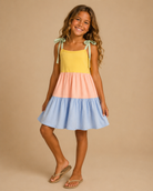 Young girl wearing a colorful dress with a beige background