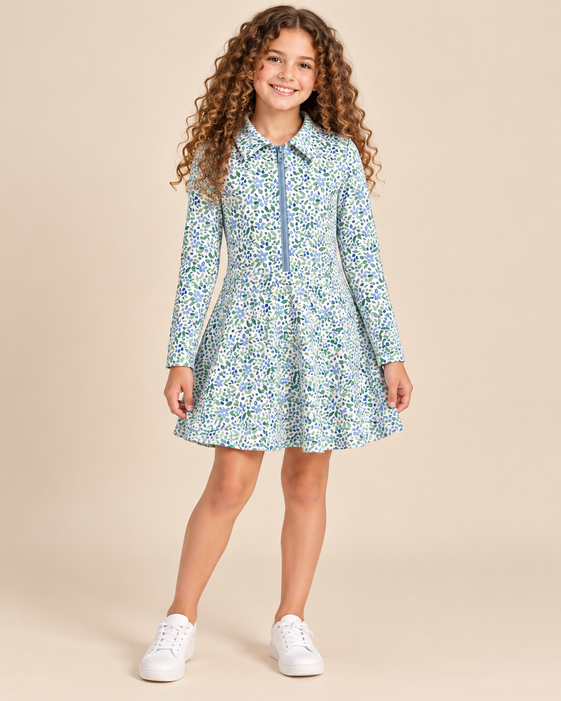Tween girl wearing a floral print quarter zip dress on beige background.
