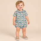 Toddler boy wearing a fish print bubble on a beige background.