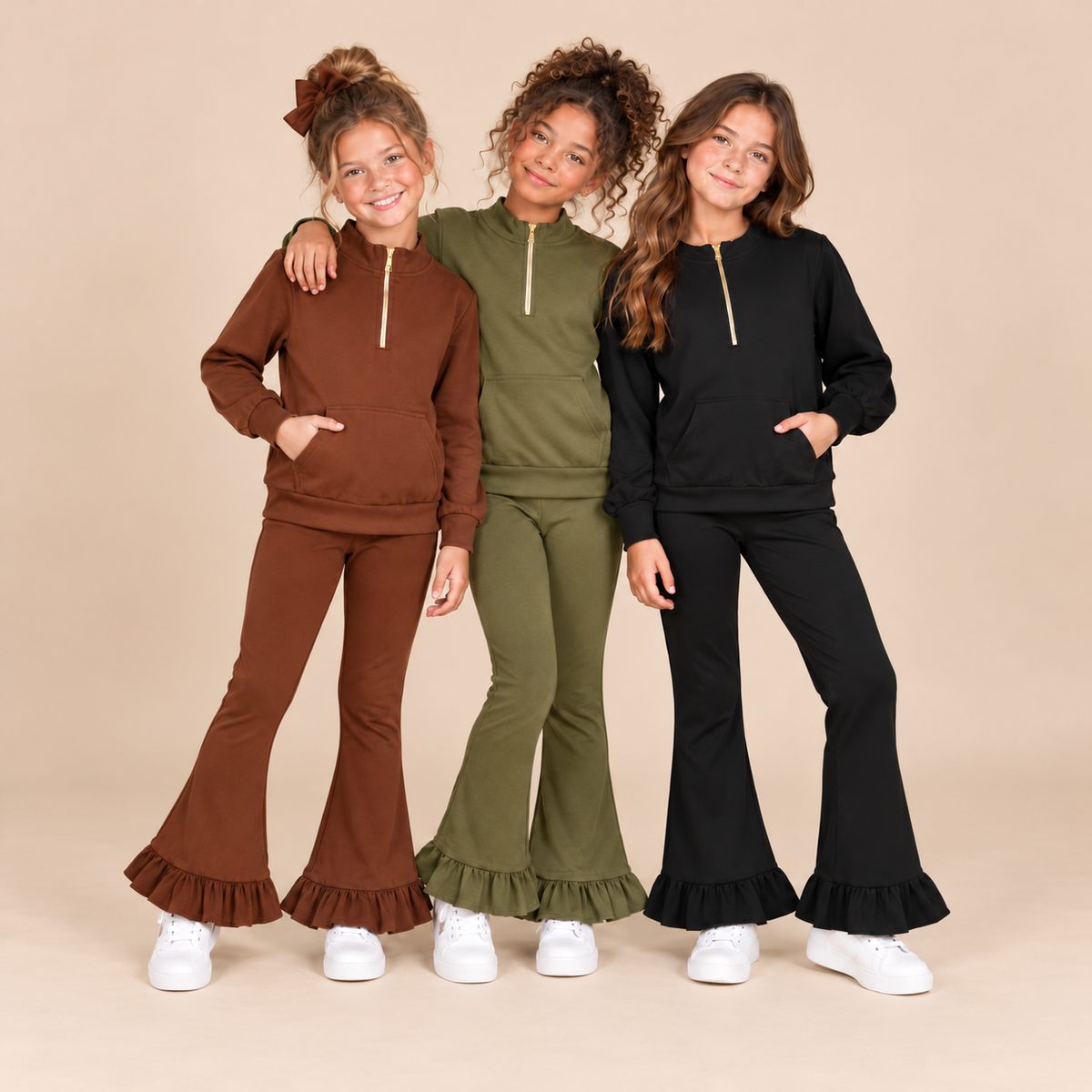 Three girls wearing a brown, olive, and black quarter zip pant sets.