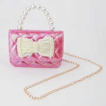 Pink handbag with a bow and pearl handle on a white background