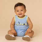 Infant boy wearing construction bubble on beige background.