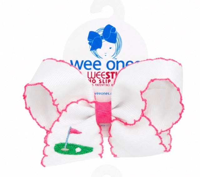 White hair bow with pink trim and golf design, branded 'wee ones'.