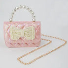 Pink handbag with a bow and pearl handle on a light gray background
