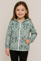 Young girl wearing a green floral patterned hoodie against a plain background.