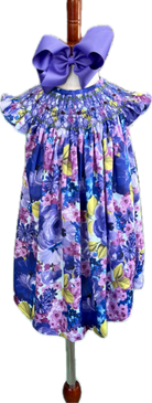Floral dress with a large purple bow on a mannequin against a white background