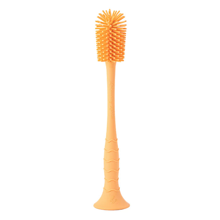 Orange silicone bottle brush on a white background