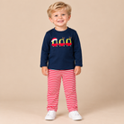 Long sleeve navy shirt with white and red striped pants.