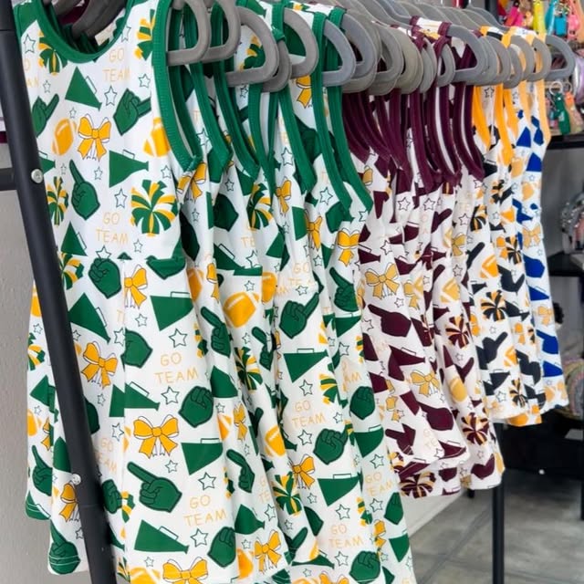 Children's dresses with sports team patterns on hangers