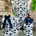 Children's outfit with navy and white pattern on mannequins in a store setting.