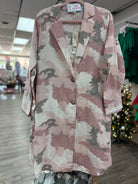 Camouflage-patterned jacket on a hanger in a store setting