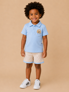 Boy wearing blue doodle dog polo shirt and plaid shorts set