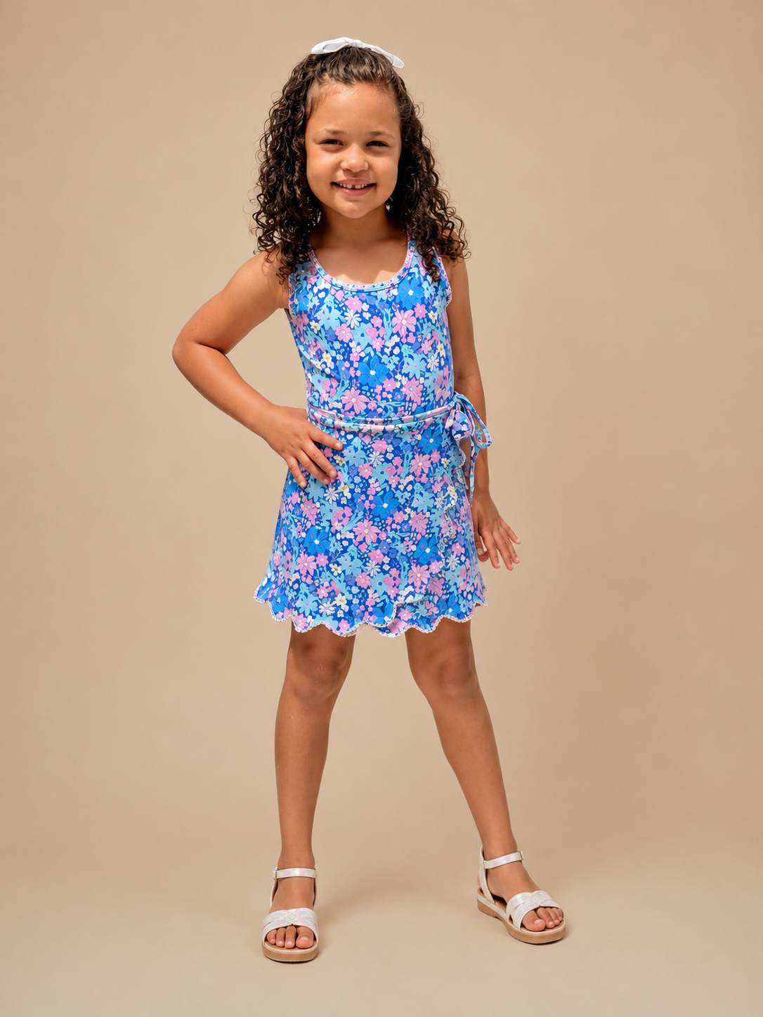 Young girl wearing a blue floral dress on a beige background
