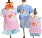 Children's clothing set with pink tank tops and blue shorts featuring pumpkins on mannequins.