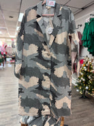 Camouflage shirt on a hanger in a store setting with Christmas decorations.