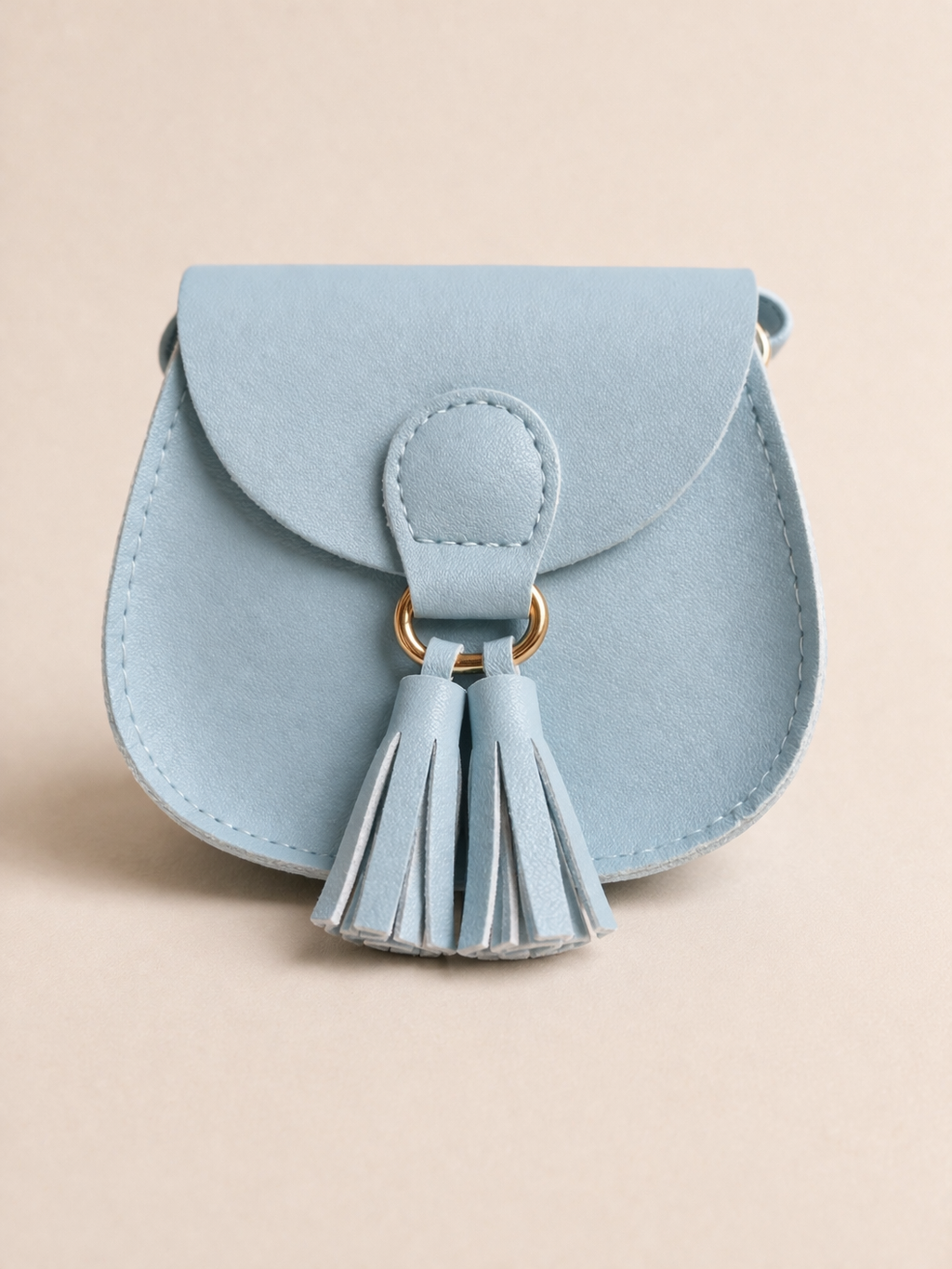 Light blue handbag with a tassel on a beige background