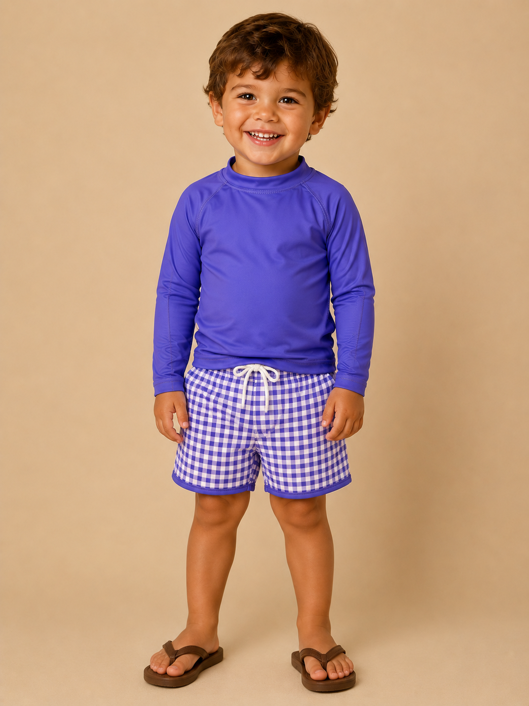Child wearing a purple long-sleeve shirt and checkered shorts on a beige background
